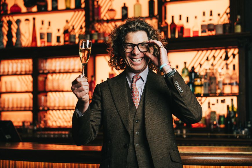 Tom Gilbey holding a glass of wine